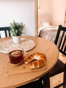 uma mesa com um prato de pão e uma chávena de café em Forest House Augustów em Augustów