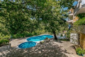 una piscina en un patio con un árbol en Poolside Apartments Miljan i Ranko, en Herceg-Novi