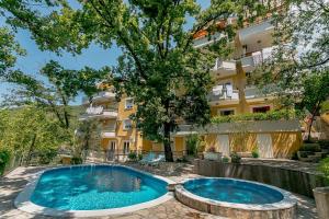 Apartamento con 2 piscinas frente a un edificio en Poolside Apartments Miljan i Ranko, en Herceg-Novi