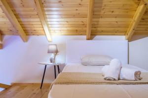 a bedroom with a bed and a wooden ceiling at La Pietra Maisonettes in Neokhórion