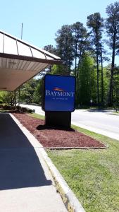 ein blaues Schild für ein Baymont-Schild an der Straßenseite in der Unterkunft Baymont by Wyndham Williamsburg in Williamsburg