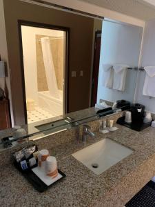 Comfort Inn Crystal Lake - Algonquin في كريستال ليك: منضدة حمام مع حوض ومرآة كبيرة