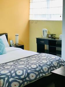 um quarto com uma cama, uma secretária e uma janela em Casa Prada Bed & Breakfast em Bogotá