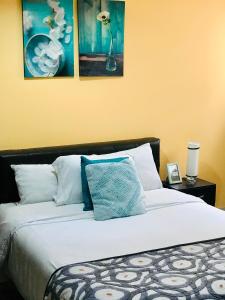 a bed with a white comforter and pillows on it at Casa Prada Bed & Breakfast in Bogotá