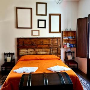 a bedroom with an orange bed with two towels on it at Controvento B&B in Marsala