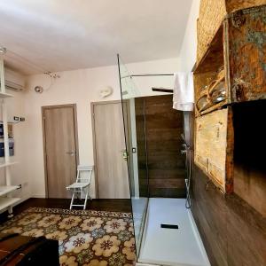 a glass shower in a room with a chair at Controvento B&B in Marsala +28 photos
