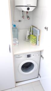 a laundry room with a washing machine and a microwave at S&H La Malasaña in San Vicente del Raspeig