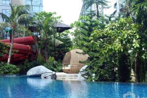 una piscina en un complejo con un tobogán de agua en Cozy & Elegant The Mansion Jasmine Tower Capilano, en Yakarta