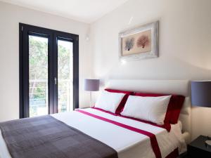 um quarto com uma cama grande e almofadas vermelhas e brancas em WLofts 11, 12 & 14 by Klodge em Olbia