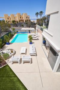una foto di una piscina con sedie a sdraio e di un resort di Villa Flamencos Rosas, Costa Adeje a Playa Paraiso