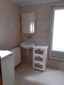 a white bathroom with a sink and a mirror at Apartman MITIĆ in Požarevac