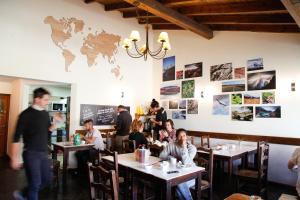 a group of people sitting at tables in a restaurant at Condor De Los Andes in El Chalten