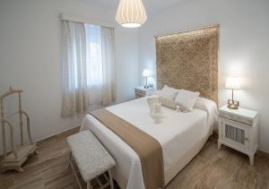 een witte slaapkamer met een groot bed en een raam bij Apartamento Garum in Cádiz