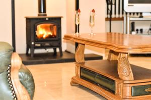 a living room with a table and a fireplace at Glenshane Country House in Maghera