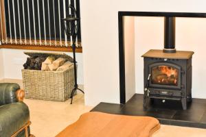 a living room with a stove and a couch at Glenshane Country House in Maghera