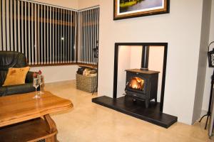 a living room with a wood stove in it at Glenshane Country House in Maghera +15 photos