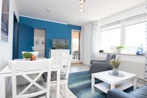 un soggiorno con pareti blu e tavolo e sedie di Haus Meeresgruß Sunshine a Grömitz