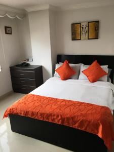 sypialnia z dużym łóżkiem z pomarańczowymi poduszkami w obiekcie Hotel Fénix Real Bogotá w mieście Bogota
