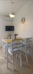 einen Esstisch und Stühle mit einem Tisch und einer Uhr in der Unterkunft Apartman Lapis in Savar