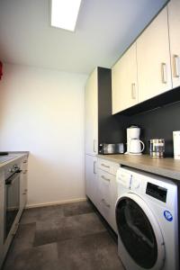 a kitchen with a washing machine in a kitchen at Ferienwohnung SEE - ZEIT in Immenstaad am Bodensee +3 photos