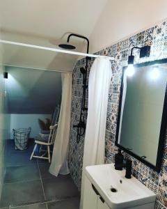 een badkamer met een wastafel en een tv aan de muur bij Apartments Sandra in Lovran +21 foto's