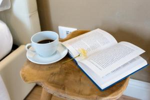 a cup of coffee and an open book on a table at Maison Garibaldi in Cagliari