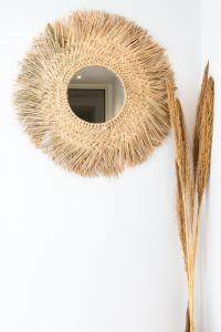 a round mirror on a white wall with feathers at Maison Garibaldi in Cagliari