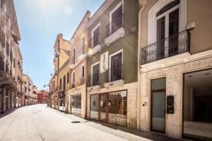 an empty street in a city with buildings at Maison Garibaldi in Cagliari