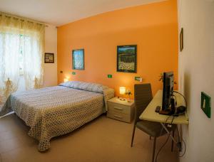 a bedroom with a bed and a desk with a television at Affittacamere a due passi dal mare in Marina di Cecina