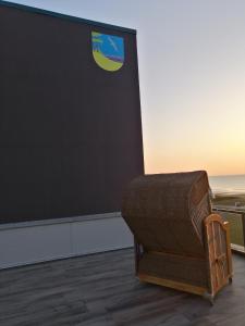 a wooden bench sitting on top of a sandy beach at Beachhotel Sahlenburg - Adults Only - Boutiquehotel in Cuxhaven
