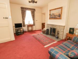 a living room with a couch and a fireplace at Manor Cottage in Wooler