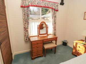 a dressing table with a mirror and a window at Foxglove Covet in Wooler