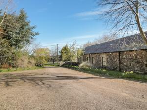 an empty road in front of a stone building at Foxglove Covet in Wooler