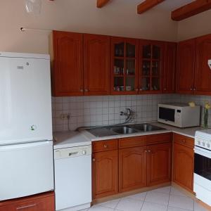 a kitchen with a white refrigerator and a sink at Pitypang Vendégház Villány in Villány
