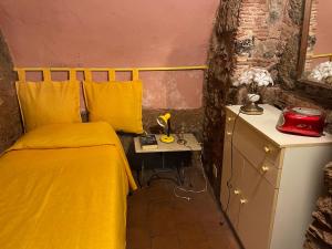 a bedroom with a yellow bed and a table at Antica Casa Centro in Catania