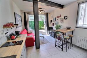 een keuken en een woonkamer met een rode bank bij Appartement centre-ville avec terrasse INDUS in Vannes