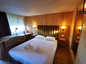 um quarto de hotel com uma cama com duas toalhas em The Originals Access, Hôtel Foix (P'tit Dej-Hotel) em Foix