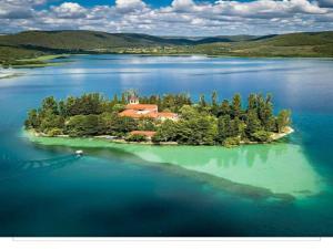 an island in the middle of a large body of water at Holiday Home Goga in Drniš