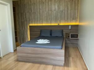 um quarto com uma cama e uma cabeceira em madeira em Motel Passione em Pinhais