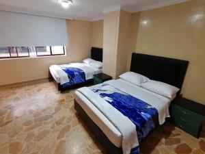 Habitación de hotel con 2 camas y 2 ventanas en HOTEL GOLDEN SUITE, en Pereira