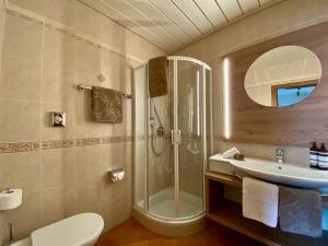 un bagno con doccia, WC e lavandino di Stauder a Dobbiaco