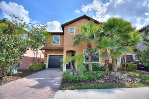 a house with a palm tree in front of a driveway at Havilah Vacation Villas Resort Club in Davenport