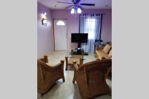 a living room with a couch and chairs and a tv at Shalom apartment in Scarborough