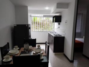 a kitchen with a table and a kitchen with a stove at 3'min del Parque del Café Apto y Piscina in Montenegro