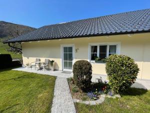 een wit huis met een tafel en stoelen in een tuin bij Ferienwohnung am Traunsee in Altmünster