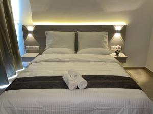 a large white bed with two white towels on it at La Veranda Hotel in Larnaca