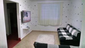 Una sala de estar con un sofá y una ventana. en Casa Toda, en São Vicente
