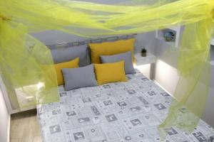 een slaapkamer met een bed met een gele baldakijn bij SS.casavacanza in Napels