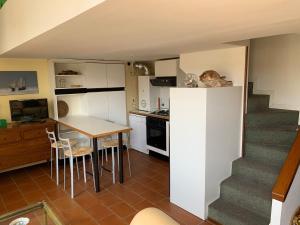 a kitchen and dining room with a table and a staircase at Seaside in Bordighera