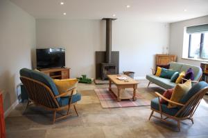 a living room with chairs and a fireplace at Wonderfully Spacious Luxury Holiday Cottage in Billingshurst